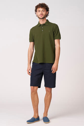 Polo verte à manches courtes verte de Bruce & Butler, portée avec un short bleu marine et des mocassins bleus.