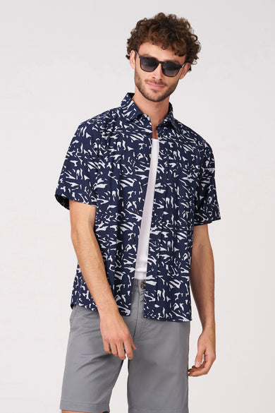 Chemise bleue à manches courtes de Bruce & Butler, à motif blanc, vue de dos, associée à un short gris.