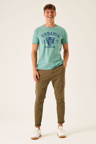 Groen T-shirt met korte mouwen van GARCIA, met een print op de voorkant, gecombineerd met kaki broek en witte sneakers.

