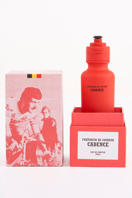 Rode parfum drinkfles van Cyclo Club Marcel, met bijpassende verpakking versierd met een figuur en de Belgische vlag.

