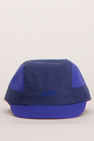Blauwe pet van Cyclo Club Marcel, met het logo "CCM" erop geborduurd.