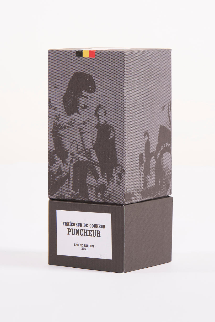 Parfum noir de Cyclo Club Marcel, avec un motif à carreaux et un drapeau belge sur le dessus de la boîte.