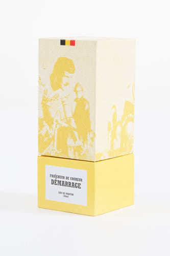 Gele parfum van Cyclo Club Marcel, met afbeelding van een wielrenner en de Belgische vlag op de doos.
