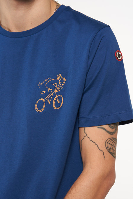 T-shirt bleu à manches courtes de Cyclo Club Marcel avec broderie orange d'un cycliste et texte 'freedom', col rond, écusson sur la manche, vue latérale en gros plan