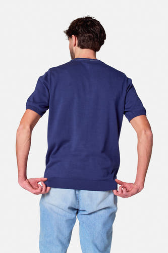 Blauw poloshirt met korte mouwen van Cyclo Club Marcel, gezien vanaf de achterkant, met lichte jeans.