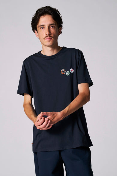 T-shirt bleu à manches courtes du Cyclo Club Marcel, avec trois badges sur la poitrine.