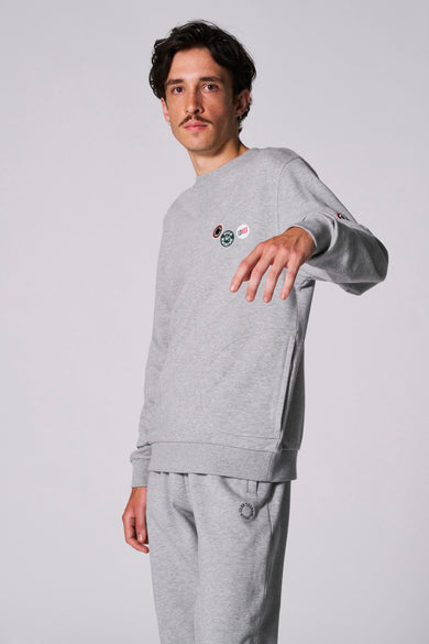 Pull gris à col rond de Cyclo Club Marcel, vu de derrière avec un short de jogging coordonné.