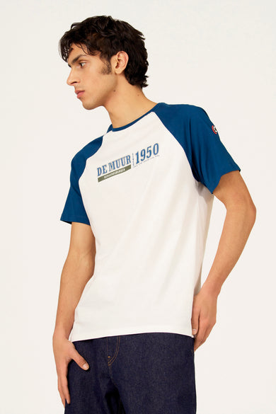 Wit T-shirt met korte blauwe mouwen van Cyclo Club Marcel, met opschrift en gedragen met een donkere jeans.
