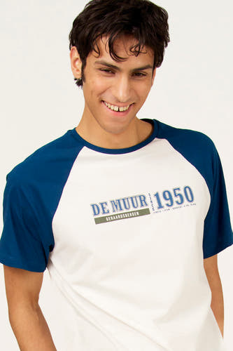 T-shirt blanc à manches courtes Cyclo Club Marcel, avec manches raglan bleues et imprimé sur la poitrine.