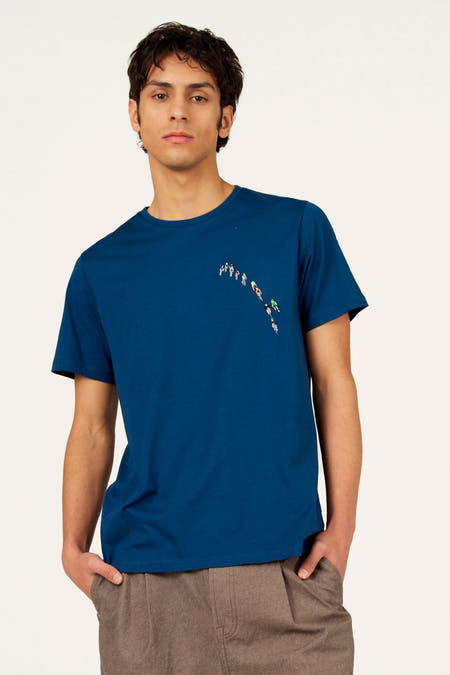 Blauw T-shirt met korte mouwen van Cyclo Club Marcel, met een print van wielrenners, gedragen met een bruine broek.
