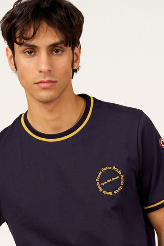 T-shirt bleu à manches courtes de Cyclo Club Marcel, avec des accents jaunes sur le col et les manches, et un logo rond imprimé.