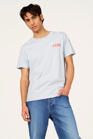 T-shirt bleu à manches courtes de Cyclo Club Marcel, avec imprimé vélo rouge au dos, combiné avec un jean.