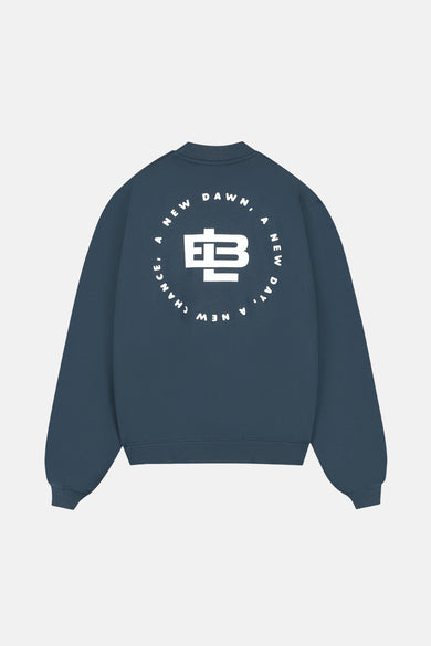 Pull-over bleu de BASELAB, avec une impression blanche sur le dos et un col rond.