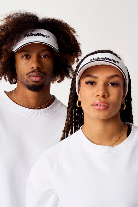 Witte pet van COELY, gedragen door twee modellen met bijpassende witte sweaters.