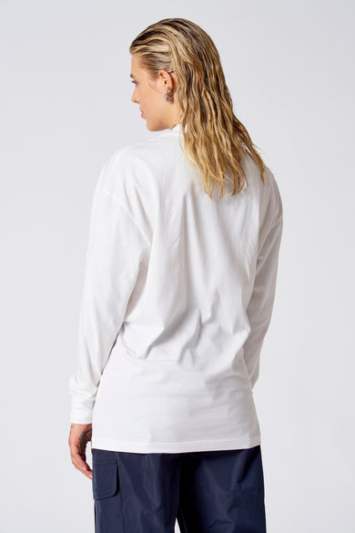 Off-white denim T-shirt met lange mouwen van COELY, rugaanzicht, gecombineerd met een blauwe broek.
