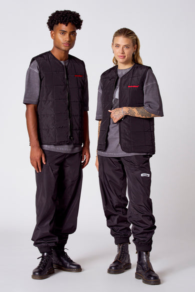 Gilet de corps noir de COELY, vu de de derrière, avec un motif tricoté et porté sur une chemise grise.