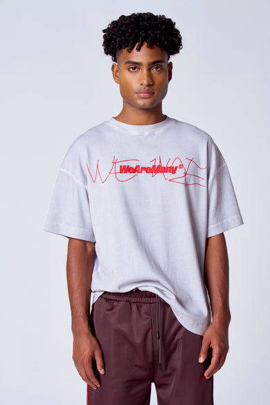T-shirt gris à manches courtes de COELY, avec une impression de texte rouge et porté avec un short d'entraînement marron.