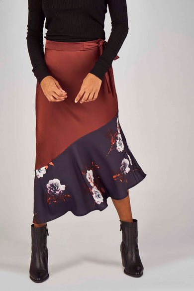 Bordeaux rok van Clouds of Fashion met bloemenprint aan de onderkant en zwarte laarzen.
