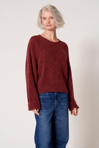 Bordeaux trui met ronde hals van Clouds of Fashion, gedragen met blauwe jeans.
