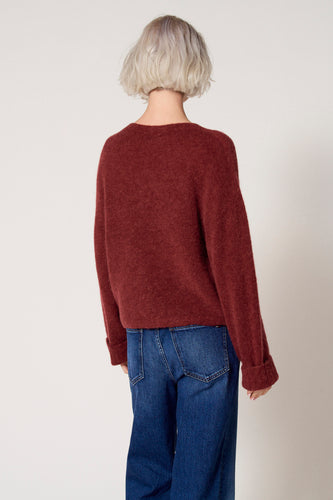 Bordeaux trui met ronde hals van Clouds of Fashion, achterkant, gecombineerd met een blauwe jeans.
