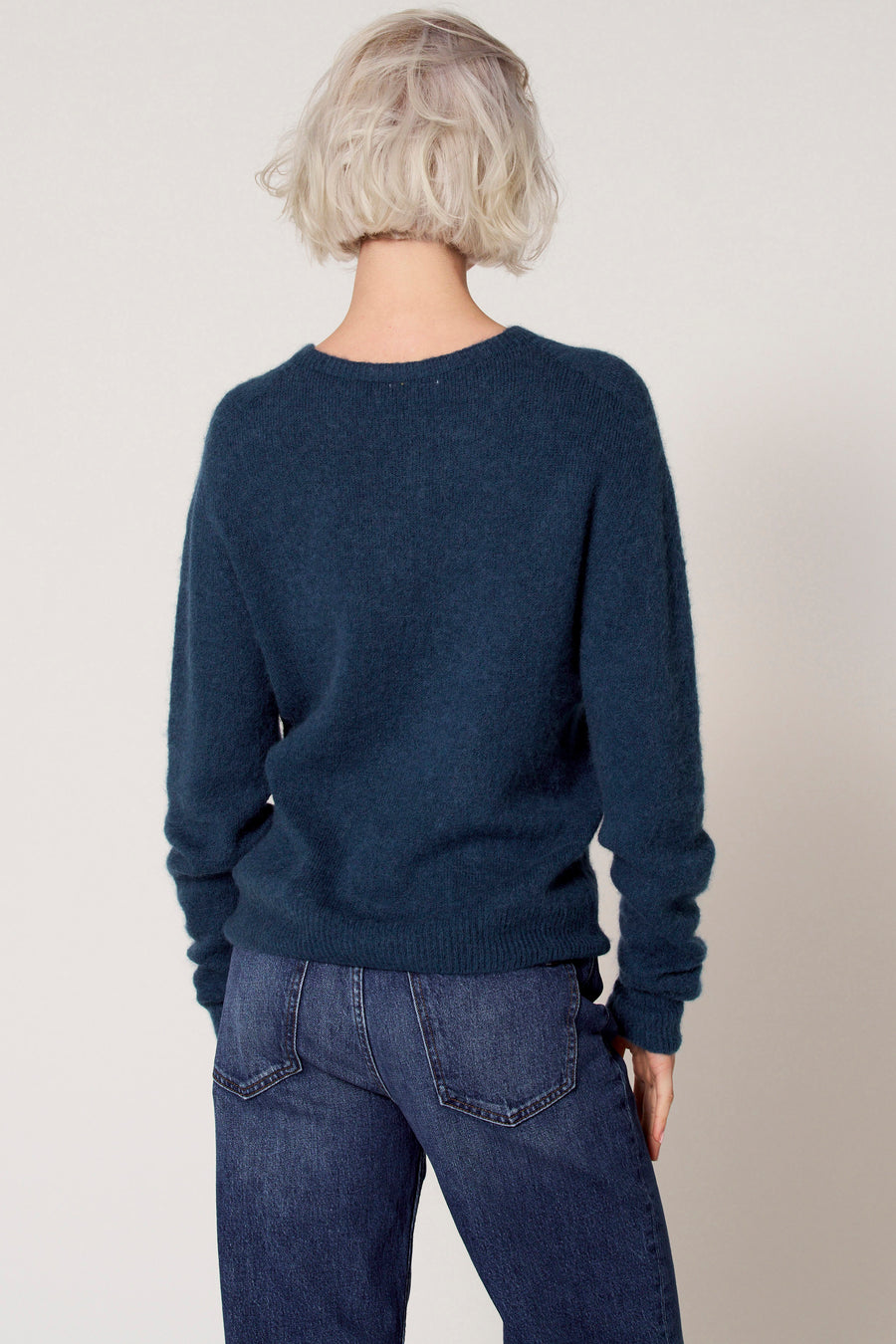 Blauwe trui met ronde hals van Clouds of Fashion, met lange mouwen en gedragen over een donkere jeans.
