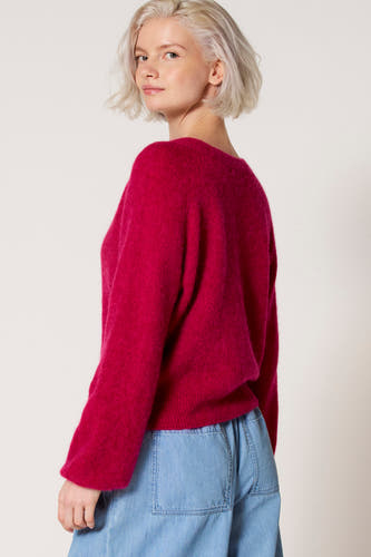 Roze V-hals trui van Clouds of Fashion, gedragen met een lichtblauwe broek.
