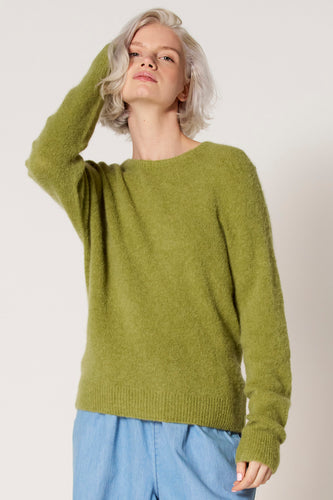 Groene trui met ronde hals van Clouds of Fashion, gedragen met een lichtblauwe broek.