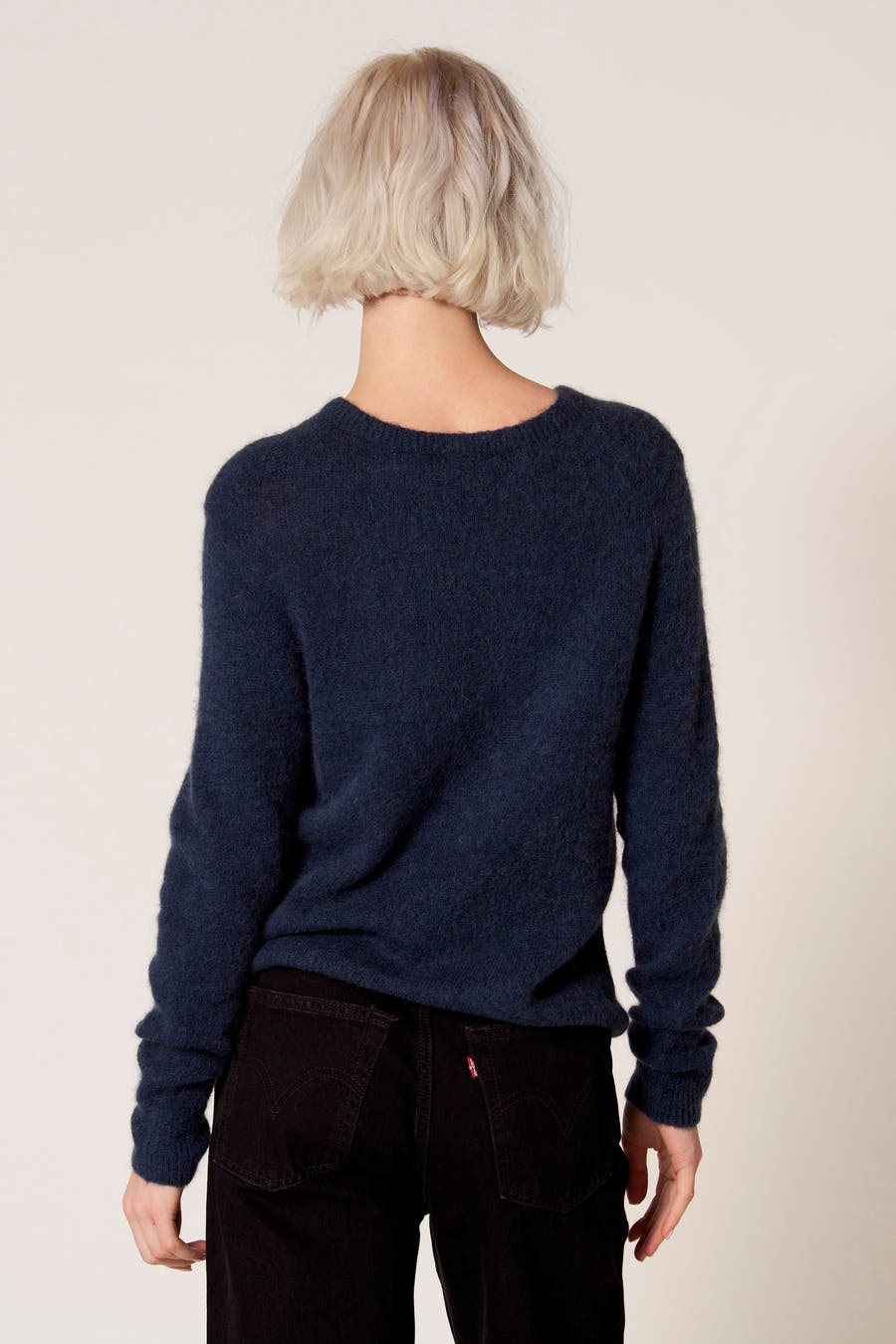 Blauwe trui met ronde hals van Clouds of Fashion, gezien van achteren, gecombineerd met een zwarte broek.
