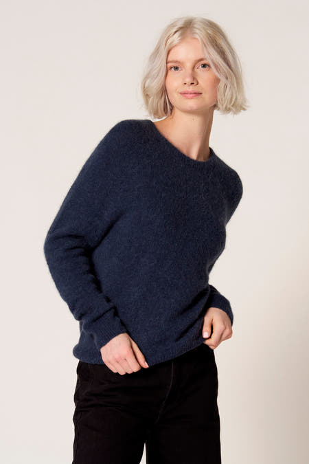 T-shirt bleu avec col rond de Clouds of Fashion, à longues manches et en douce texture, porté avec un pantalon noir.