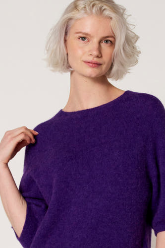 Paarse trui met ronde hals van Clouds of Fashion, close-up van de voorkant, gedragen door een vrouw met platinablond haar.
