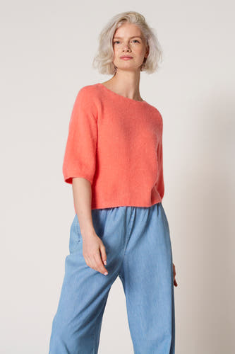 Roze trui met ronde hals van Clouds of Fashion, gedragen met lichtblauwe broek.