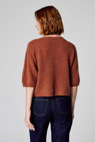 Bruine trui met ronde hals van Clouds of Fashion, met korte mouwen, gecombineerd met een donkere jeans.
