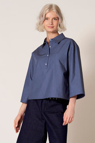 Chemisier bleu à manches trois-quarts de Clouds of Fashion, avec poche poitrine et porté avec un jean foncé.
