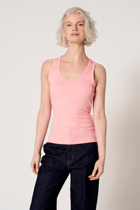 Débardeur rose de Clouds of Fashion, porté avec un jean bleu foncé.