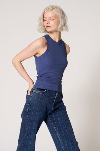 Blauwe singlet van Clouds of Fashion, met een ronde halslijn, gedragen met een blauwe jeans met strepen.