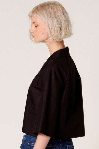 Zwarte blouse van Clouds of Fashion, in zijaanzicht gedragen met een blauwe jeans.
