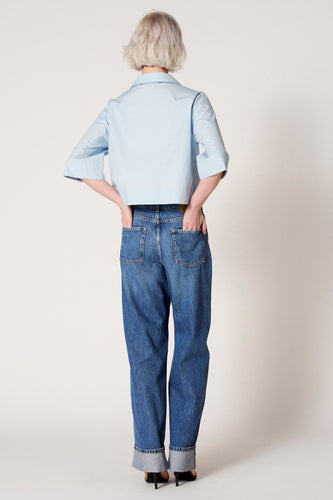 Blouse bleue de Clouds of Fashion, avec des manches trois-quarts, portée avec des jeans et des bottes noires, dos.