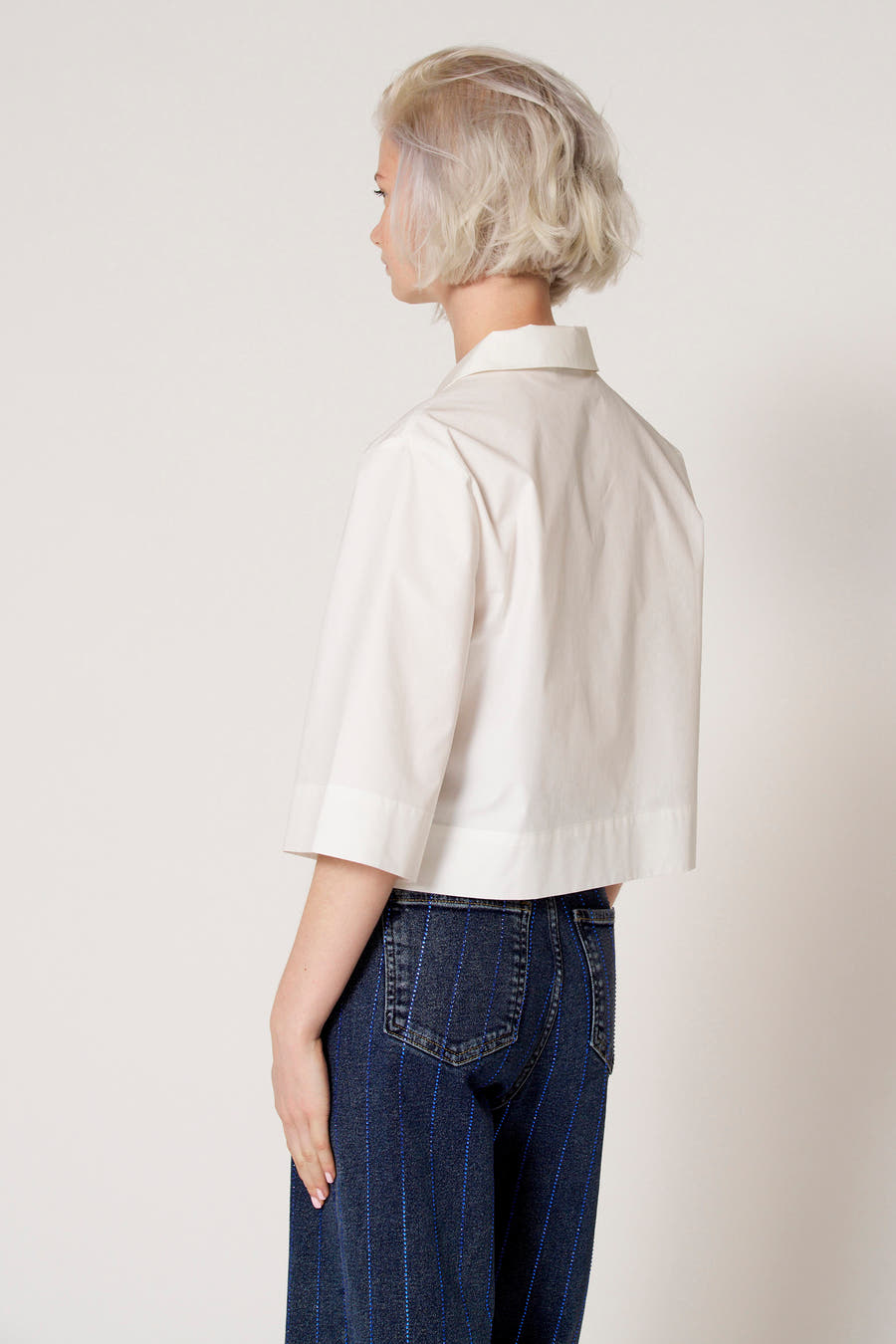 Witte blouse met driekwart mouwen van Clouds of Fashion, met een kraag en gecombineerd met een jeans met blauwe strepen.