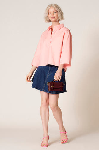 Roze blouse met driekwart mouwen van Clouds of Fashion, gedragen met een donkerblauwe rok en roze sandalen.