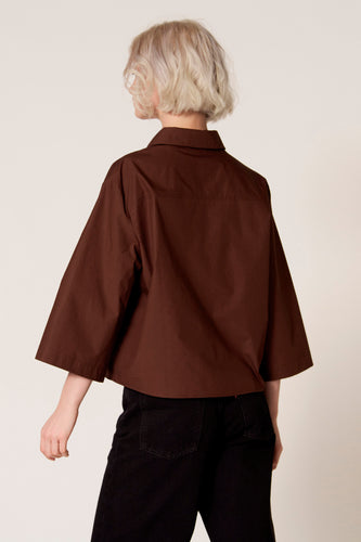 Bruine blouse van Clouds of Fashion, met driekwart mouwen, gedragen met een zwarte broek, achterkant weergegeven.
