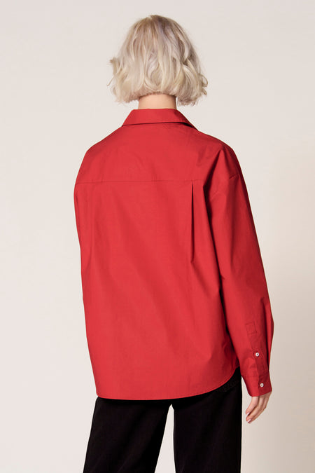 Rode blouse met lange mouwen van Clouds of Fashion, gezien van achteren, met een enkele plooi en manchetten.