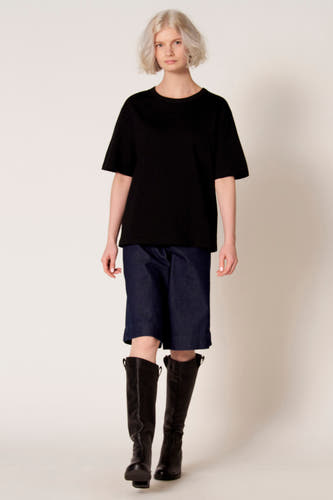 Zwart T-shirt met korte mouwen van Clouds of Fashion, met een losse pasvorm, gecombineerd met denim shorts en zwarte laarzen.