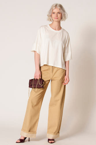 Ecru T-shirt met korte mouwen van Clouds of Fashion, gedragen met kaki broek en bordeauxrode hakken.