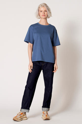 Blauw T-shirt met korte mouwen van Clouds of Fashion, gedragen met donkere jeans en kleurrijke sneakers.