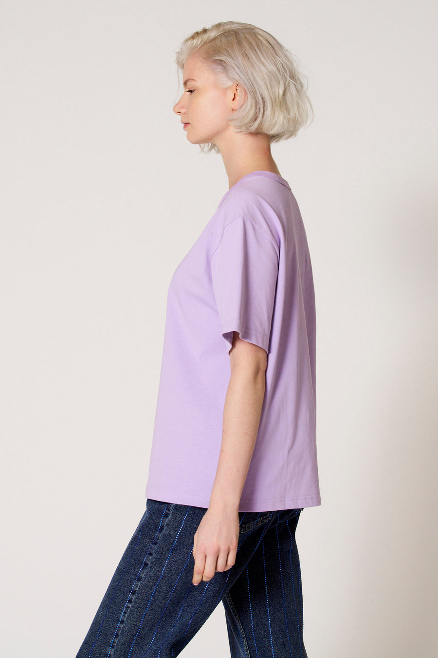 T-shirt à manches courtes violet de Clouds of Fashion, porté avec un jean bleu foncé à rayures, vue de côté.