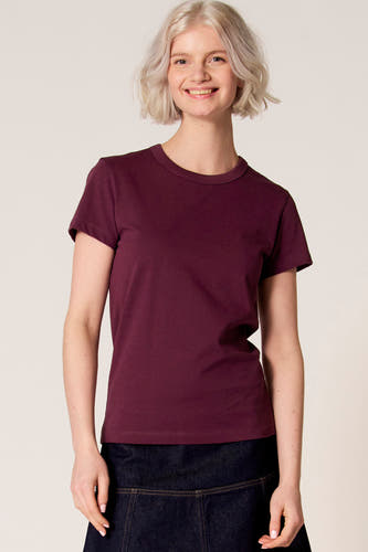 T-shirt à manches courtes violet de Clouds of Fashion, vu de dos, combiné avec une jupe bleu foncé.