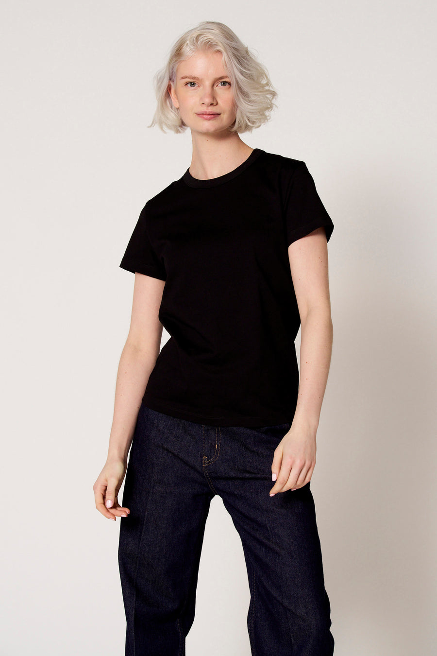 T-shirt noir à manches courtes de Clouds of Fashion, porté par une femme aux cheveux blonds courts.