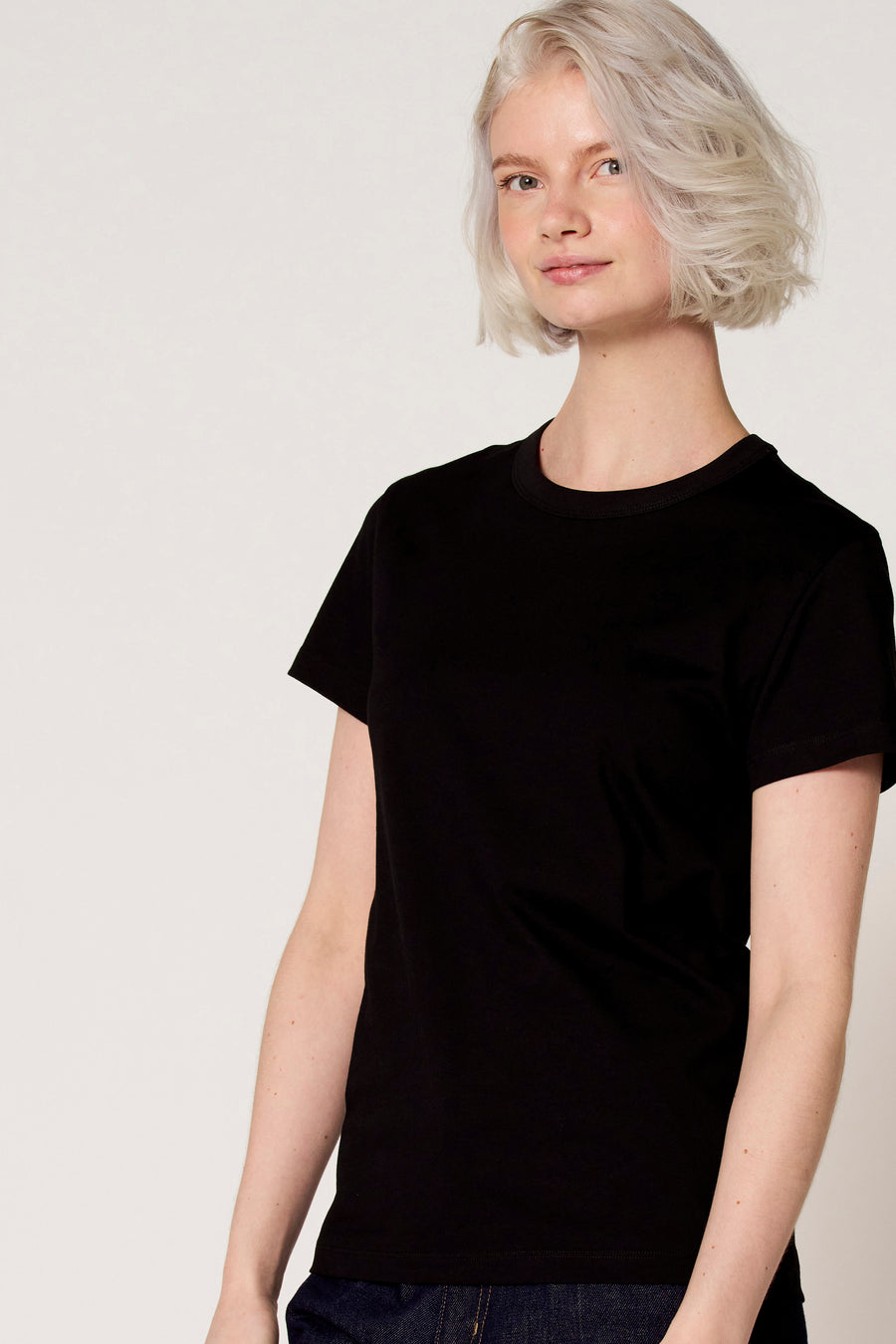 Zwart T-shirt met korte mouwen van Clouds of Fashion, gedragen door een vrouw met kort blond haar.