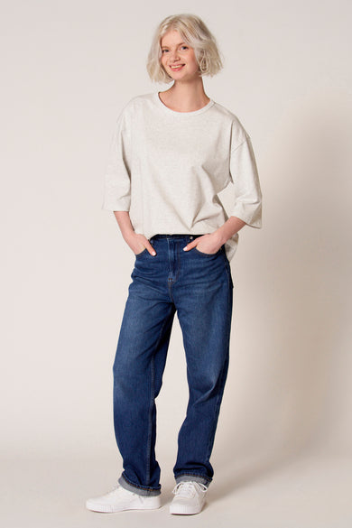Grijs T-shirt met korte mouwen van Clouds of Fashion, gedragen met blauwe jeans en witte sneakers.