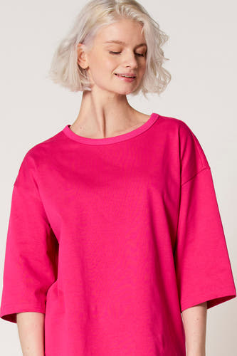 Roze T-shirt met korte mouwen van Clouds of Fashion, met een losse pasvorm en ronde halslijn, gedragen door een model.
